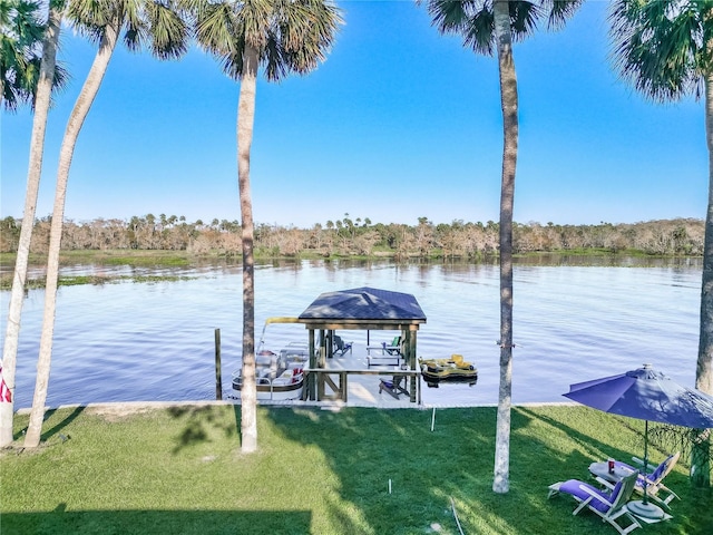 view of dock with a water view and a lawn