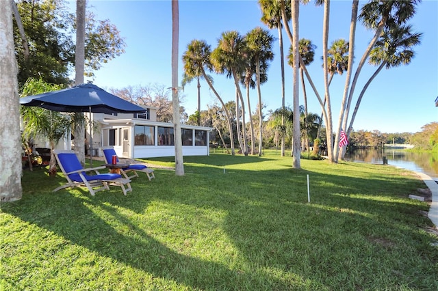 view of yard featuring a water view and a sunroom