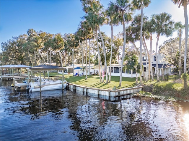 view of dock featuring a water view and a yard