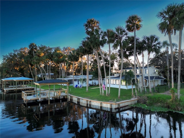 view of community with a water view, a yard, and a boat dock