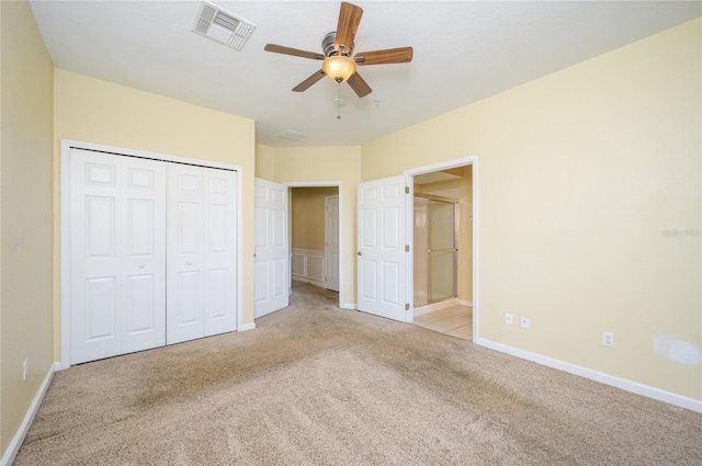 unfurnished bedroom featuring ceiling fan, a closet, and light colored carpet