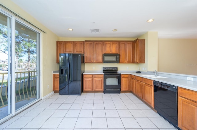 kitchen with black appliances, light tile patterned flooring, and sink