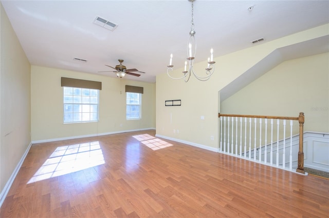 empty room with ceiling fan with notable chandelier and light wood-type flooring