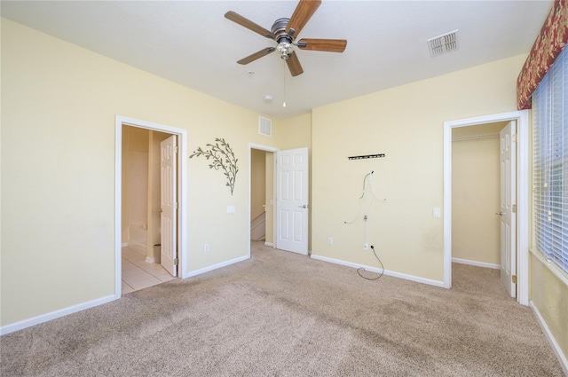 unfurnished bedroom featuring connected bathroom, ceiling fan, and light carpet