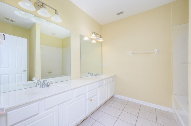 bathroom with tile patterned floors, a bathtub, and vanity