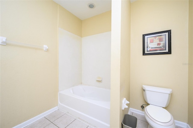 bathroom featuring tile patterned flooring, toilet, and a bathing tub