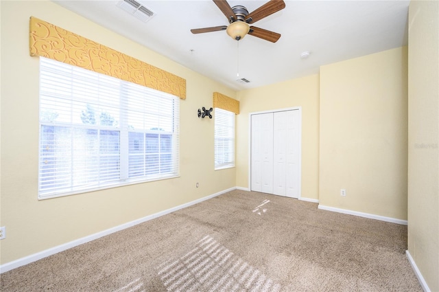 unfurnished bedroom with carpet flooring, ceiling fan, and a closet