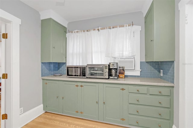 kitchen with backsplash, light hardwood / wood-style floors, and green cabinetry