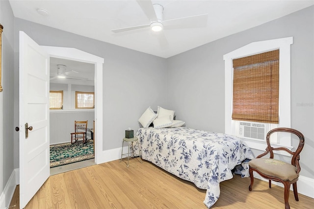 bedroom featuring ceiling fan, hardwood / wood-style floors, and cooling unit