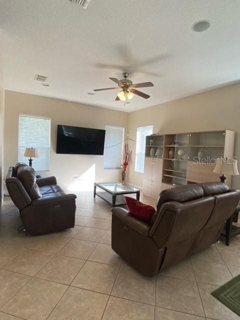 tiled living room featuring ceiling fan and plenty of natural light