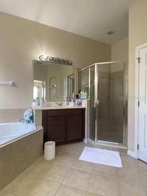 bathroom featuring tile patterned floors, vanity, and shower with separate bathtub