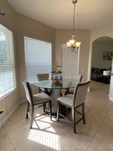 tiled dining space with an inviting chandelier