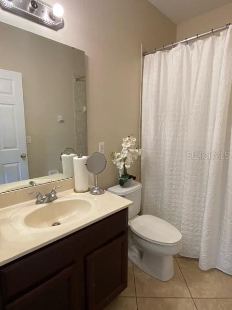 bathroom featuring toilet, vanity, and tile patterned floors