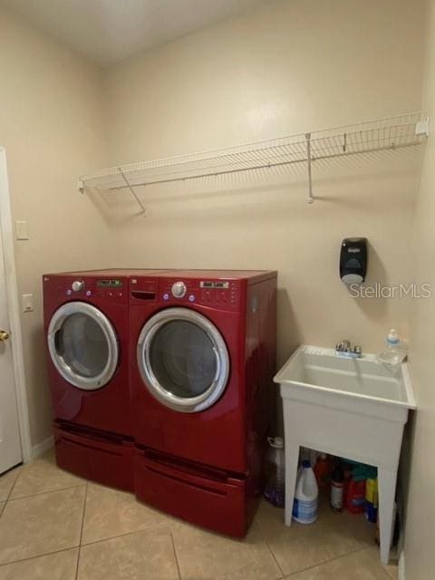 laundry area featuring washer and clothes dryer and light tile patterned floors