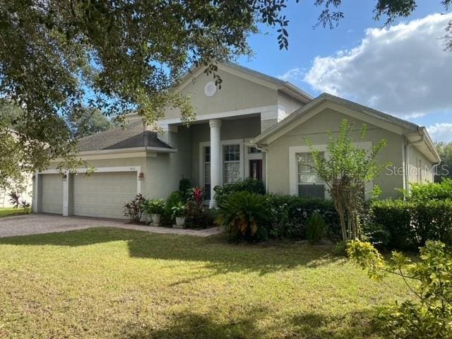 view of front of property featuring a front yard and a garage