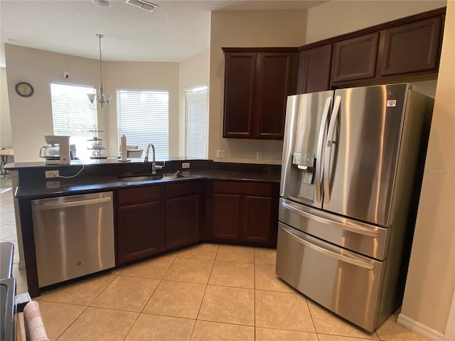 kitchen with sink, stainless steel appliances, an inviting chandelier, kitchen peninsula, and light tile patterned flooring