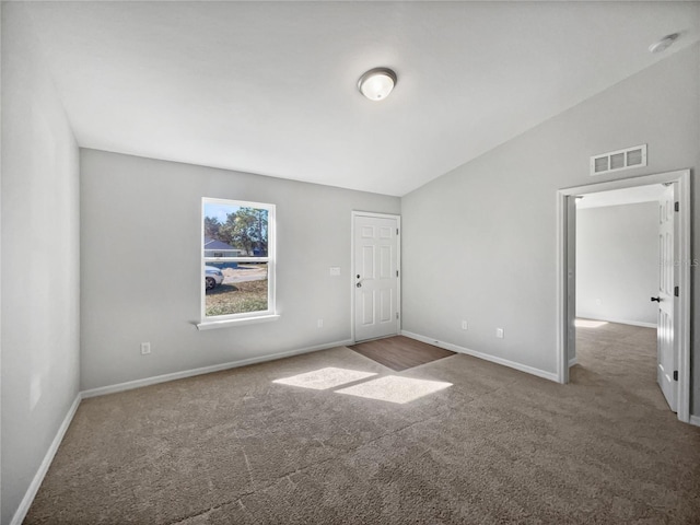 carpeted empty room with lofted ceiling