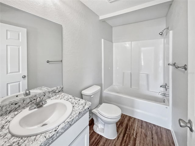 full bathroom with washtub / shower combination, hardwood / wood-style floors, vanity, and toilet