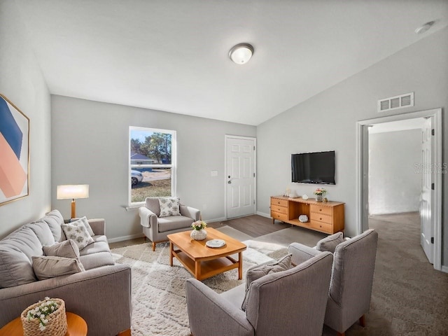 carpeted living room with lofted ceiling