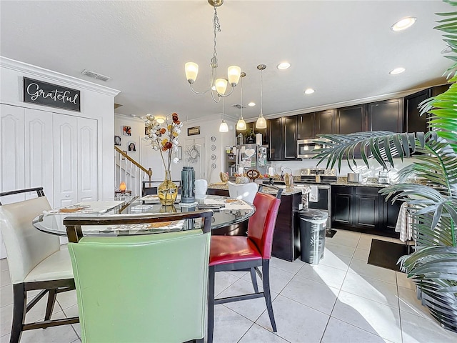 dining area with an inviting chandelier, light tile patterned floors, and ornamental molding