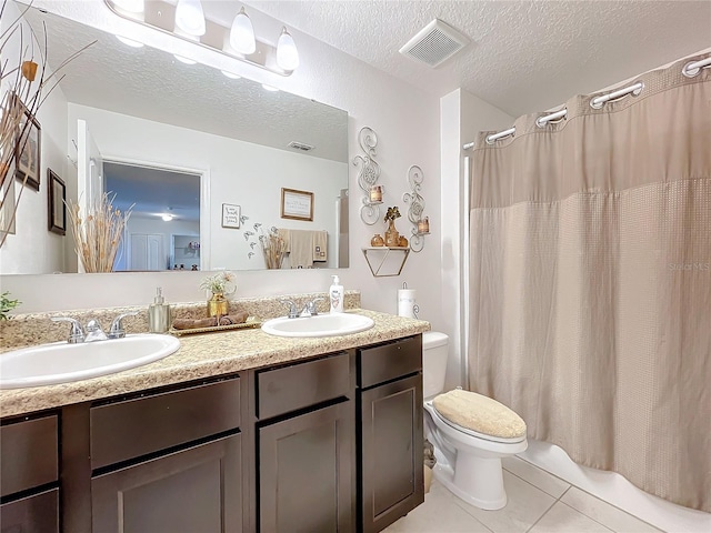 bathroom featuring tile patterned floors, vanity, a textured ceiling, and toilet