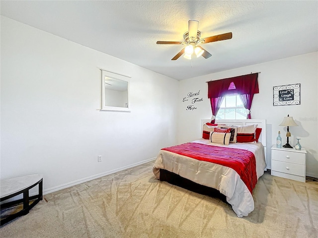 carpeted bedroom with ceiling fan and a textured ceiling