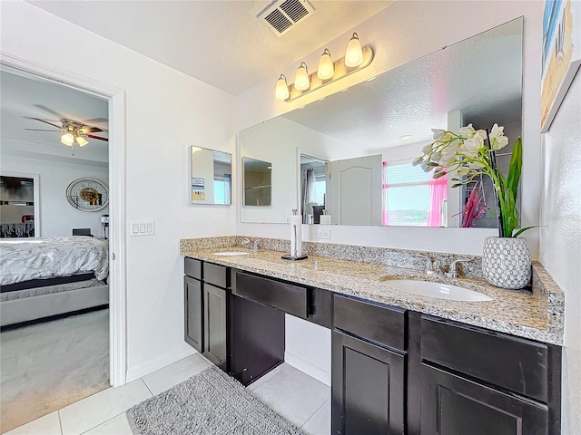 bathroom with ceiling fan, tile patterned flooring, vanity, and a textured ceiling