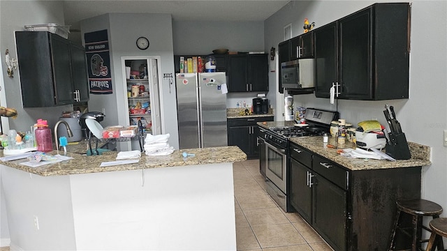 kitchen with kitchen peninsula, light stone counters, a breakfast bar, stainless steel appliances, and light tile patterned floors