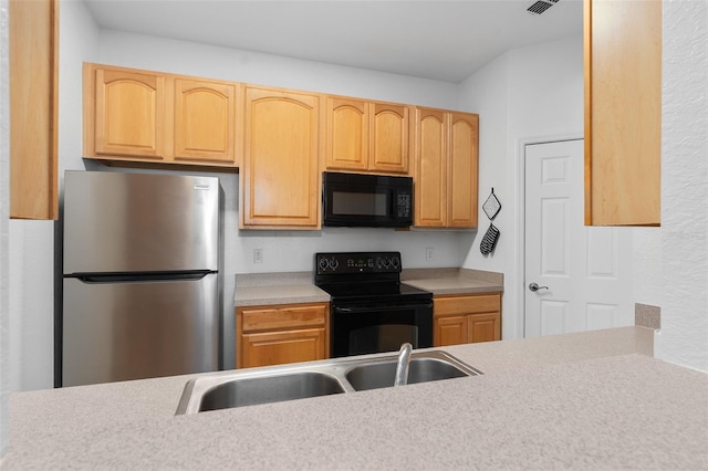 kitchen featuring light brown cabinetry, sink, and black appliances