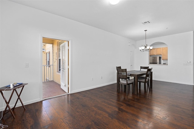 dining area featuring dark hardwood / wood-style floors and an inviting chandelier