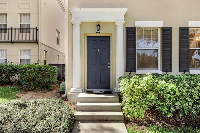 1054 Waterside Dr, Celebration, FL 34747 - doorway to property with stucco siding and central AC unit