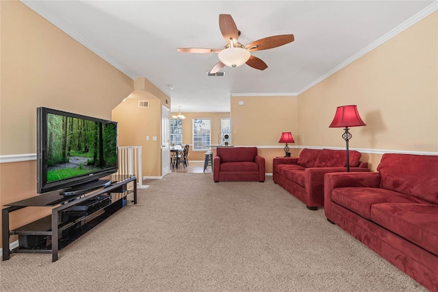 carpeted living room featuring ceiling fan with notable chandelier and crown molding