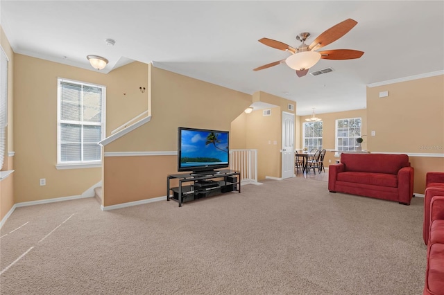 living room featuring plenty of natural light, ceiling fan, carpet floors, and ornamental molding