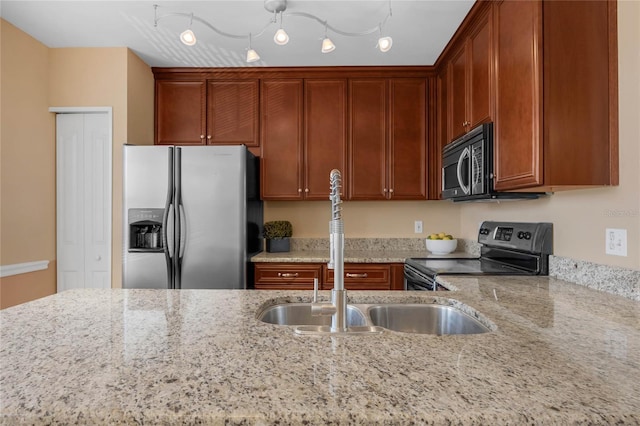 kitchen featuring light stone counters, sink, and appliances with stainless steel finishes