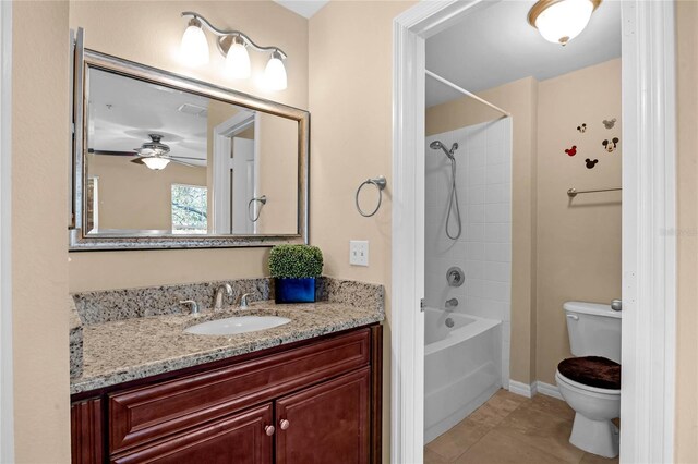 full bathroom with vanity, tiled shower / bath, tile patterned flooring, ceiling fan, and toilet