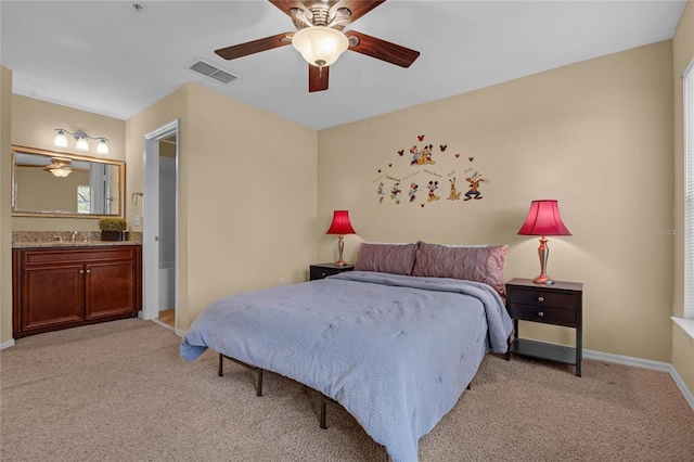 bedroom with ceiling fan, sink, light carpet, and connected bathroom