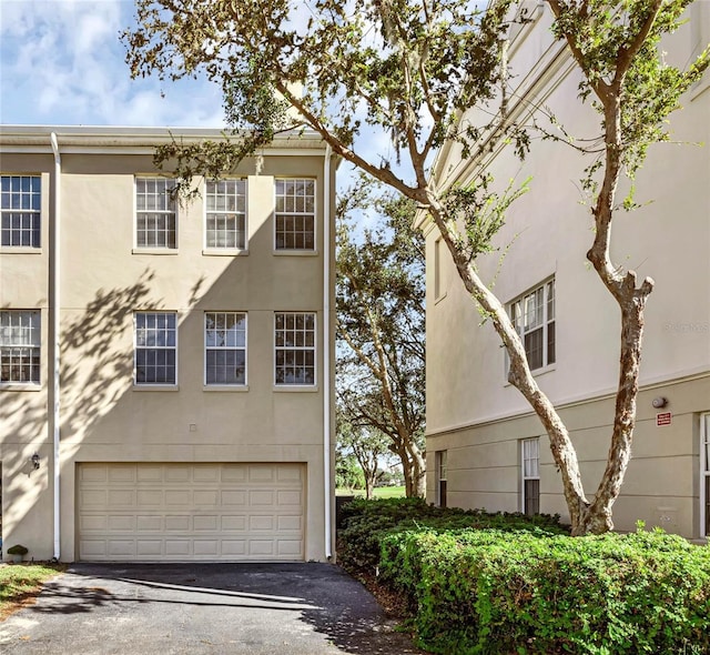 1054 Waterside Dr, Celebration, FL 34747 - view of front of house with asphalt driveway, stucco siding, and a garage