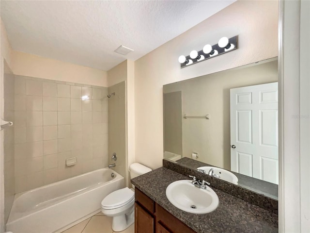 full bathroom with tiled shower / bath combo, tile patterned floors, a textured ceiling, toilet, and vanity