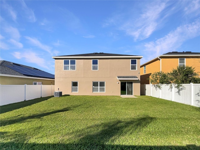 rear view of property featuring a yard and central AC