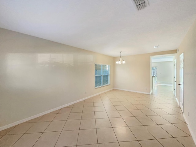 tiled empty room with a notable chandelier