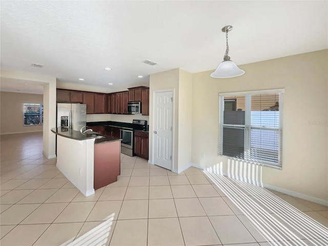 kitchen with appliances with stainless steel finishes, dark brown cabinetry, sink, pendant lighting, and light tile patterned flooring