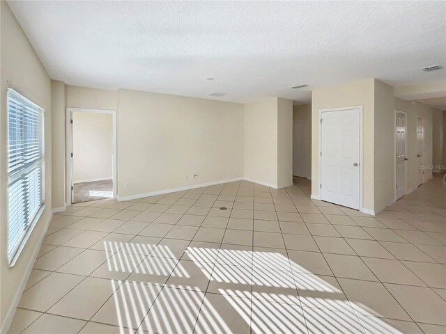 empty room featuring light tile patterned floors and a textured ceiling