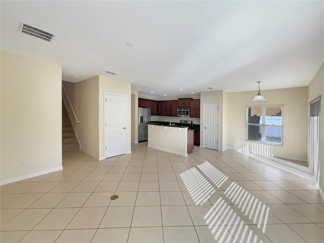 kitchen featuring appliances with stainless steel finishes, a kitchen island, hanging light fixtures, and light tile patterned flooring