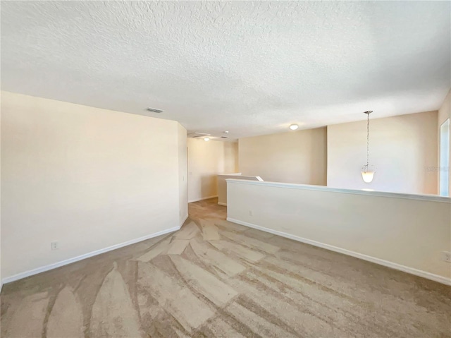 carpeted spare room with a textured ceiling