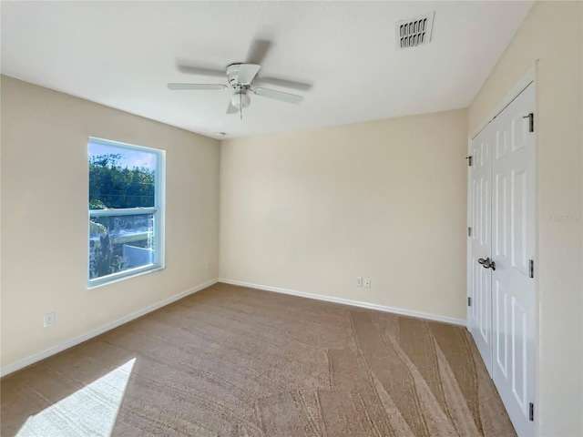 carpeted spare room with ceiling fan