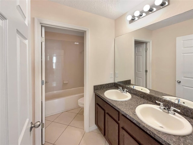 full bathroom featuring vanity, tile patterned flooring, tiled shower / bath combo, toilet, and a textured ceiling