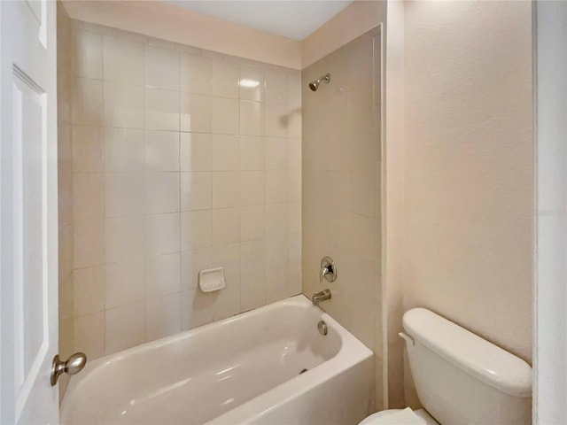 bathroom featuring toilet and tiled shower / bath