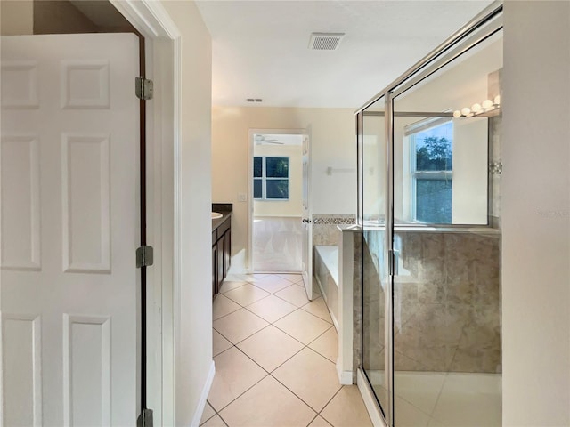 bathroom featuring tile patterned flooring, vanity, and shower with separate bathtub