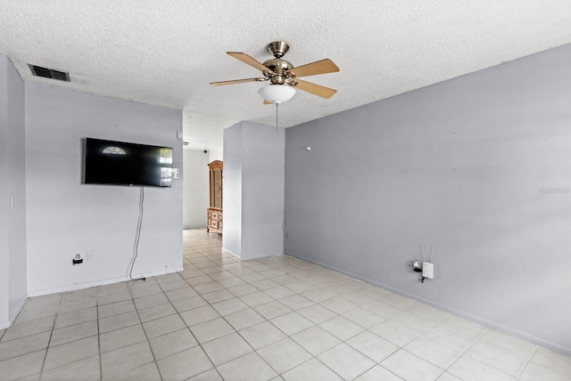 tiled empty room featuring ceiling fan and a textured ceiling