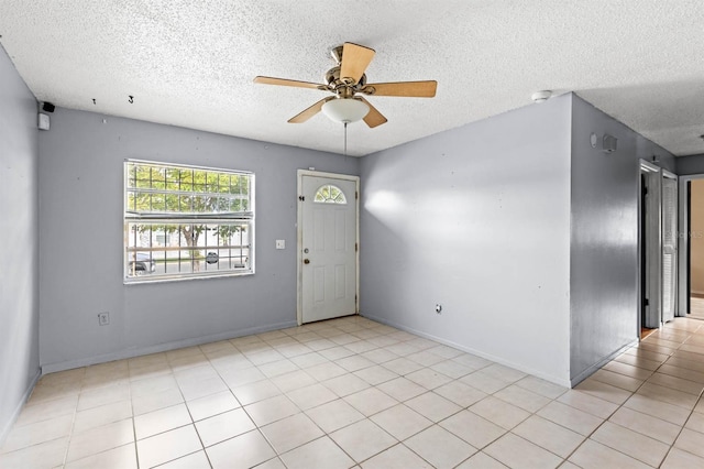 foyer featuring light tile patterned floors, a textured ceiling, and ceiling fan